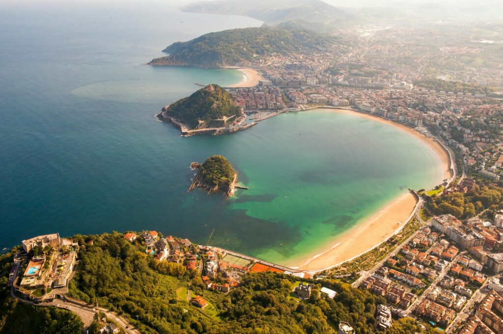 Stunning aerial shot of San Sebastián's La Concha Bay in summer sunlight.
